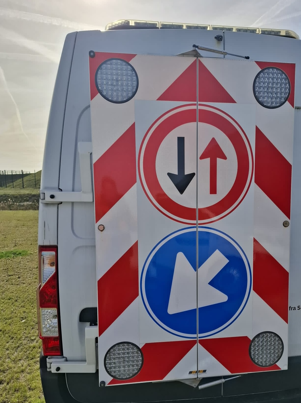BTC actieraam gemonteerd op bedrijfsvoertuig in het veld — bord met inhaalverbod en blauw richtingbord